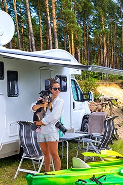 Bild: Frau mit Hund vor Wohnwagen mit Vordach